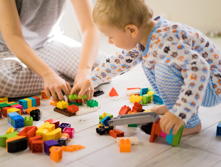 boy with mom playing in colorful building kit
