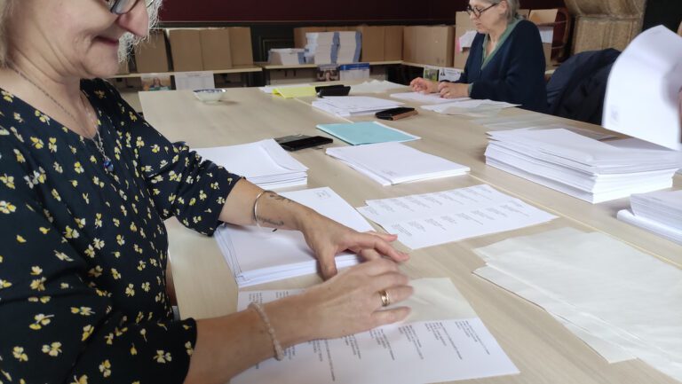 Une personne colle une étiquette sur une enveloppe
