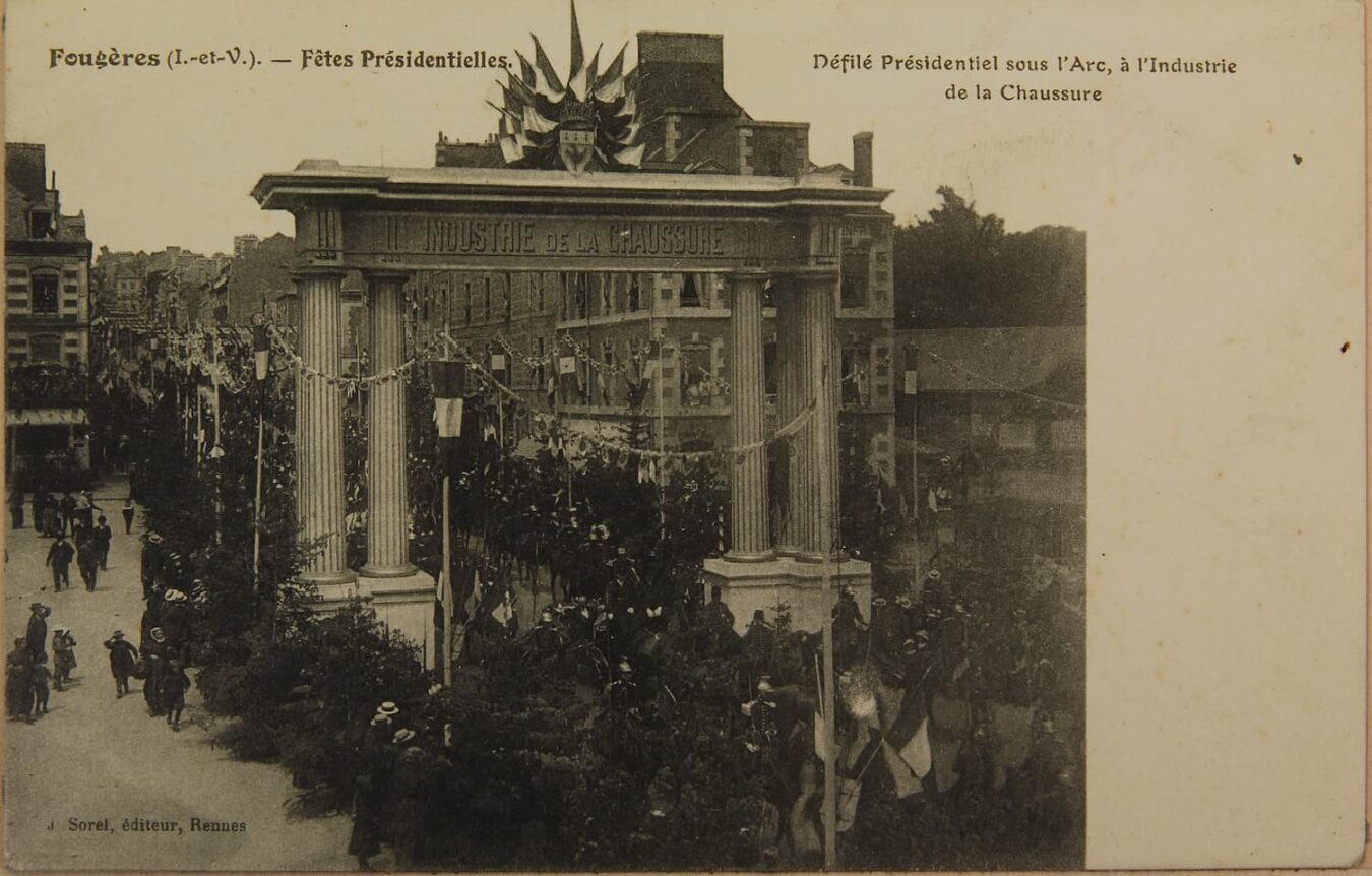 carte postale d'époque. C'est une photo d'une foule, un cortège passant sous un arc de triomphe de l'industrie de la chaussure.
